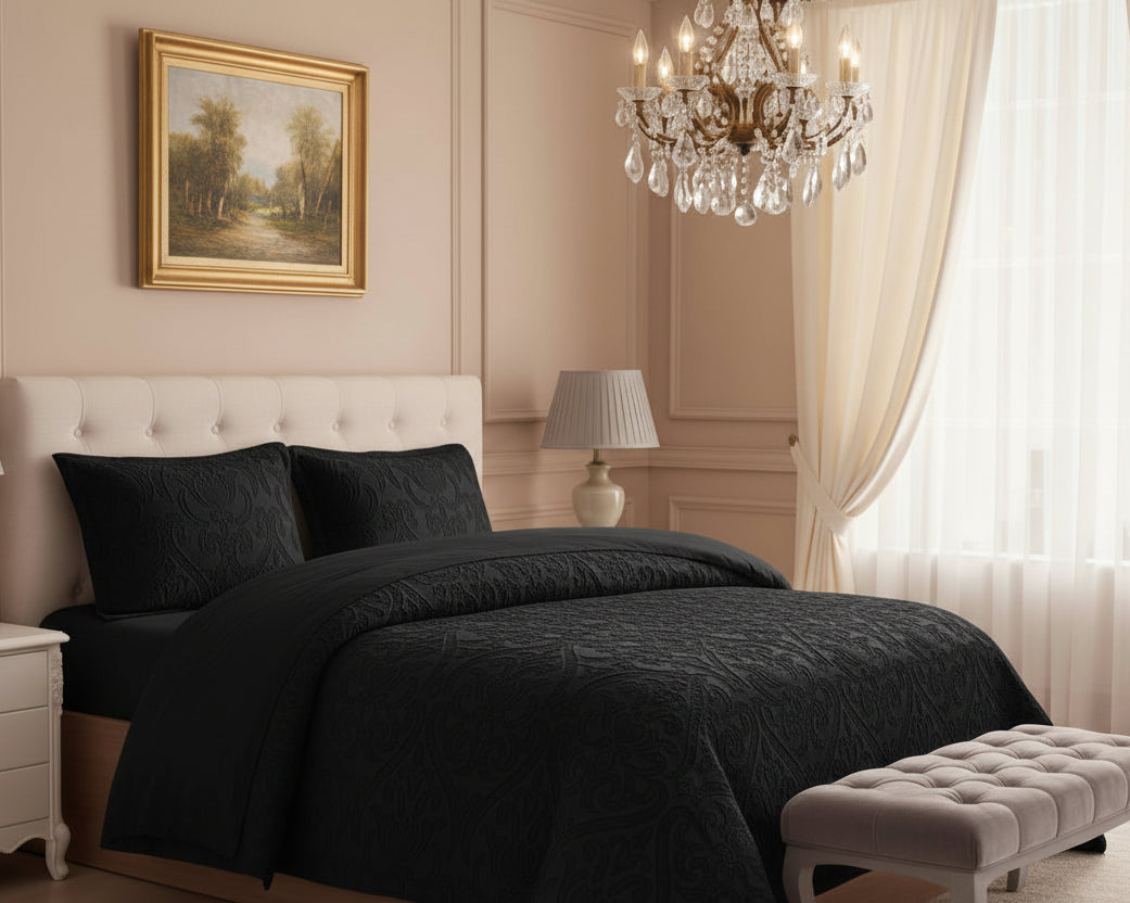 Luxurious bedroom with black bedding, white nightstands, and a chandelier.