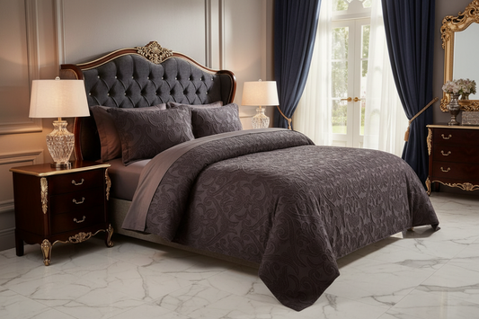 A luxury bedroom scene featuring a bed dressed in a dark gray and brown damask-patterned comforter set with matching pillows, set against a classic paneled wall with matching dark blue curtains and gold accents.
