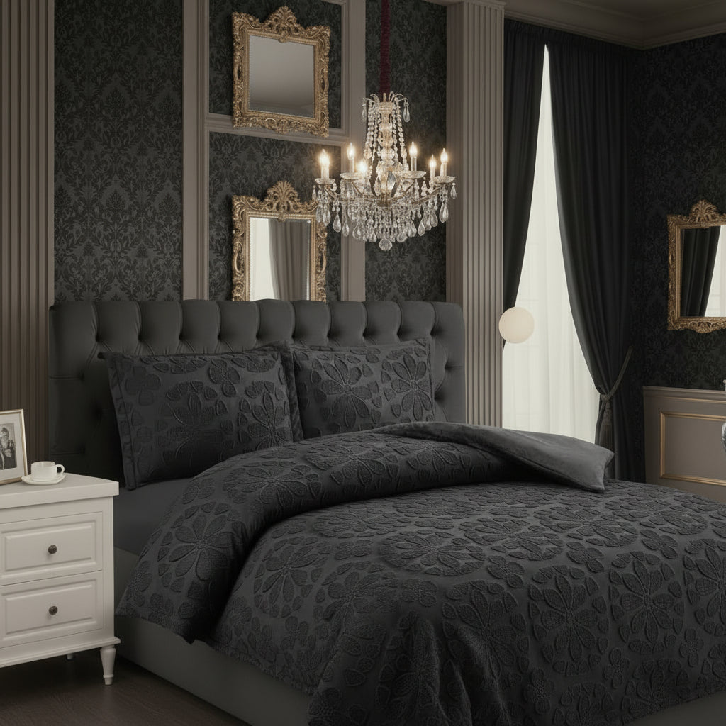 Gray bedroom with patterned bedding, chandelier, and decorative mirrors.